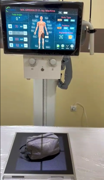 Michael ustawia lampę rentgenowską z cyfrowym detektorem z płaskim panelem, aby zapewnić precyzję na poziomie milimetr&oacute;w podczas instalacji MX-DR500A10 w Nigrze.